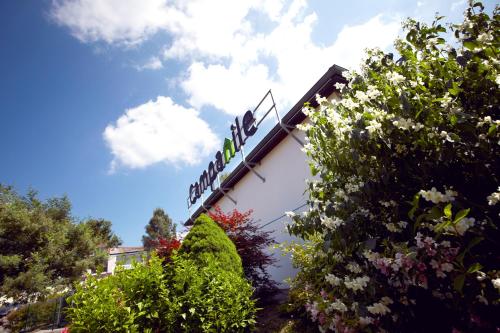 a sign on the side of a building with flowers at Campanile Dax - Saint-Paul-Les-Dax in Saint-Paul-lès-Dax