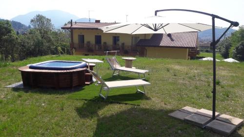 a patio with a table and a chair and an umbrella at Agriturismo La Soglia Del Parco in Ranica