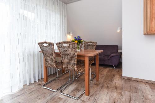a dining room table with chairs and a couch at Ferienwohnung Haus zum Seehund mit Pool und Frühstücksoption in Bensersiel