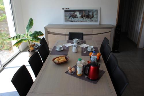 a table with food and drinks on top of it at B&B La Lyre in Saint-Georges-du-Bois