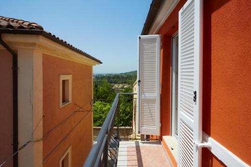 a balcony with white shutters on a building at Affittacamere Somnium in Sirolo