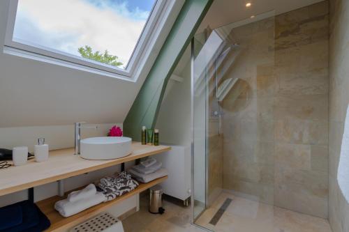 uma casa de banho com um lavatório e um chuveiro em B&B Weids em Elst