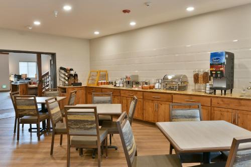 a restaurant with tables and chairs and a counter at GrandStay Hotel & Suites in Sisters