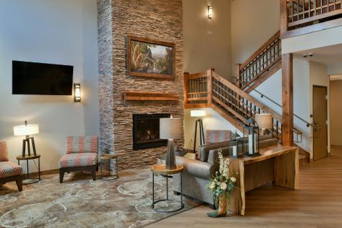 a living room with a staircase and a fireplace at GrandStay Hotel & Suites in Sisters