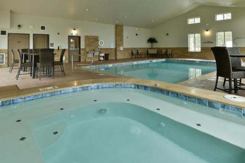 a large swimming pool with chairs and a table at GrandStay Hotel & Suites in Sisters