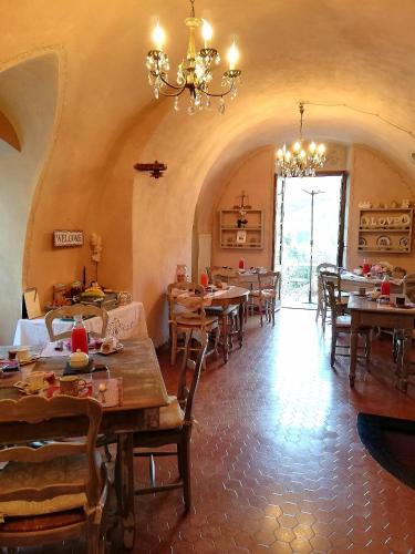 a dining room with tables and chairs and a chandelier at La Casa Rosa in Pigna