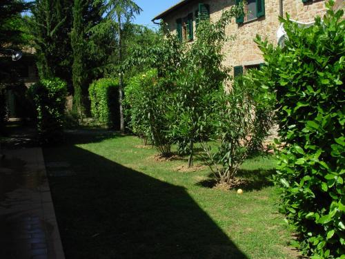 a garden with trees and a building and a yard at Borgo Il Poggio Agriturismo in Montaione