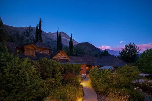 a night view of a house with trees and a road at Hotel Altiplanico Cajón del Maipo in San José de Maipo