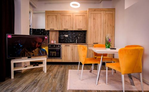 a kitchen with a table and a tv and a table and chairs at Nairi Apartment in Mamaia Nord