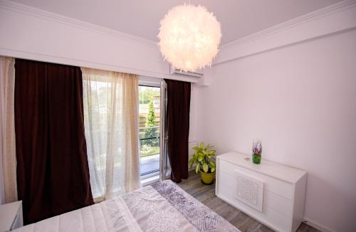 a bedroom with a bed and a large window at Nairi Apartment in Mamaia Nord