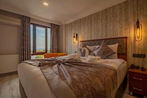 a bedroom with a large bed with a large window at Avrasya Port Hotel in Istanbul