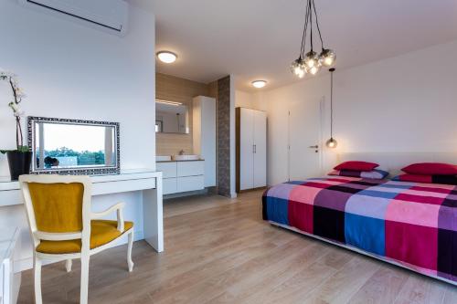 a bedroom with a bed and a desk and a chair at Villa Zarra in Klimno