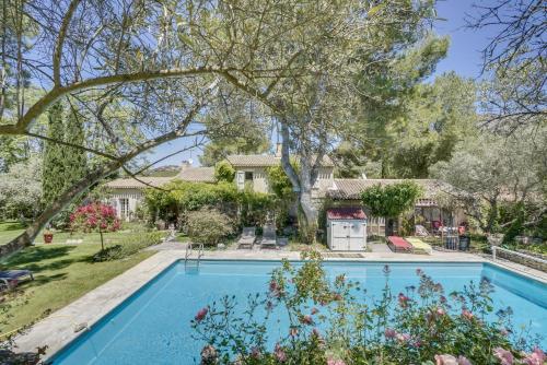 - une piscine en face d'une maison avec une cour dans l'établissement Le Mas des Anges, à Cheval-Blanc