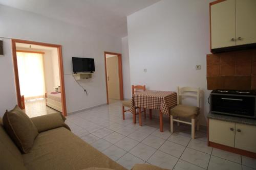 Mejdi Apartments في سارنده: غرفة معيشة بها أريكة وطاولة