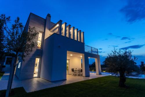 a house with a blue facade at night at Villa Zarra in Klimno