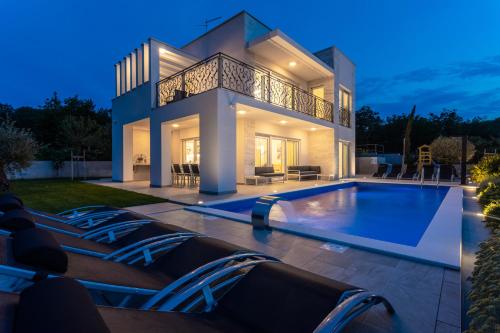 a villa with a swimming pool at night at Villa Zarra in Klimno
