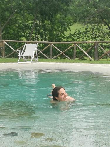 a woman in the water in a swimming pool at Frigino Agriturismo in Molino Abbadia