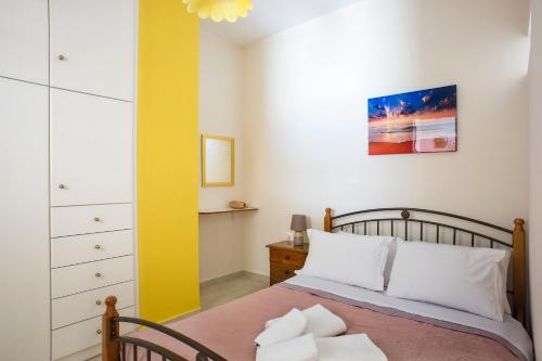 a bedroom with a bed and a yellow wall at Metela apartment in Argostoli