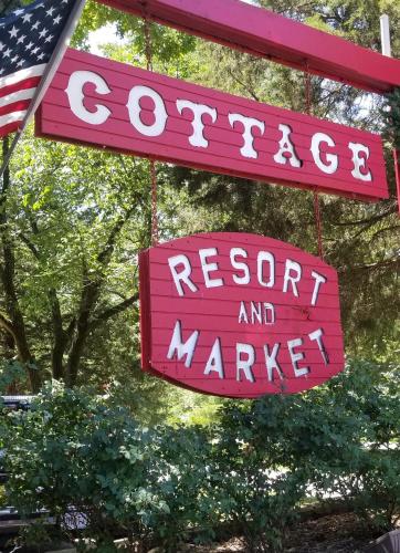 a sign for a restaurant and market with an american flag at The Cottage Resort in Branson