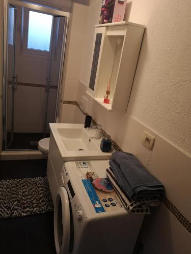 a bathroom with a washing machine and a sink at Apartmani Manda in Omišalj