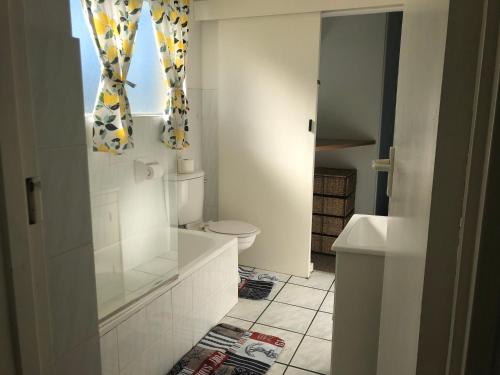 a white bathroom with a toilet and a window at 127 Hermanus Beach Club in Hermanus