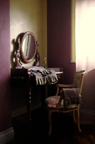 a bathroom with a mirror and a table with a chair at Relais B in Ancona