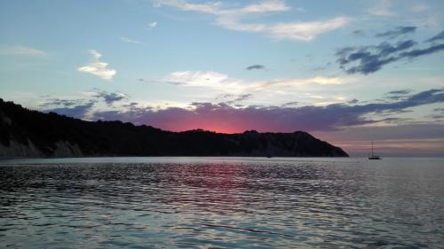 a sunset over a body of water with a boat at Relais B in Ancona
