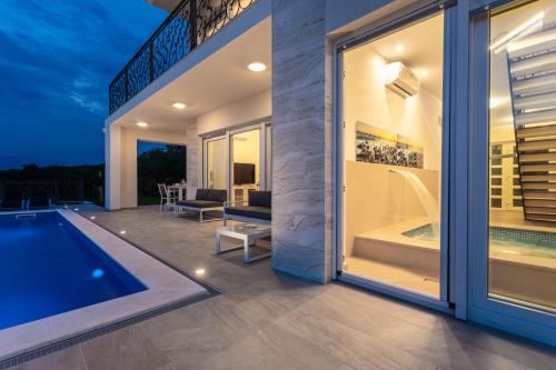 a house with a swimming pool and a patio at Villa Zarra in Klimno