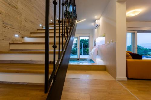 a staircase in a house with a yellow couch at Villa Zarra in Klimno