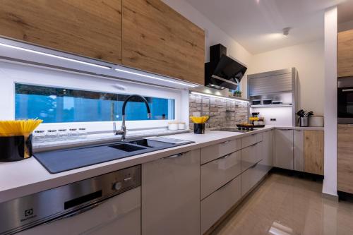 a kitchen with white cabinets and a sink at Villa Zarra in Klimno