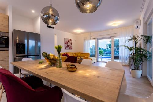 a kitchen and living room with a wooden table and chairs at Villa Zarra in Klimno