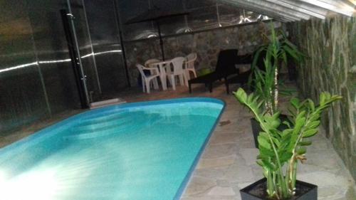 a swimming pool in a room with a table and chairs at Apartmán Ústie in Trstená