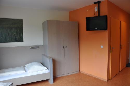 a room with a bed and a cabinet with a television at MOTEL ARBOTEL 24h self check-in in Friesach