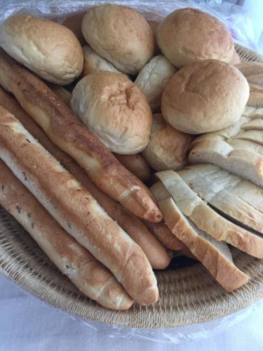 a plate of breads and buns on a table at Lake Vendégház in Alsóörs
