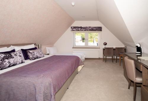 a bedroom with a large bed and a window at Seamill House Hotel in Seamill