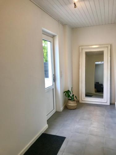 a hallway with a door and a mirror at B&B Saga in Herning