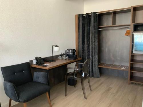 a room with a desk with a chair and a phone at Hotel am Schlosstheater in Fulda