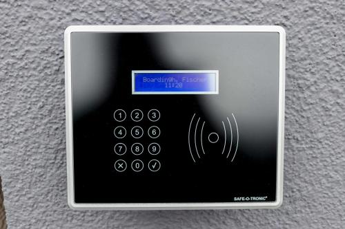 an electronic device with a button on a wall at Das Fischer Boardinghouse BW in Bad Wörishofen