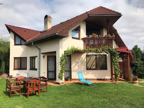 a house with a balcony and a table and chairs at Clara Valis - Village House in Doľany