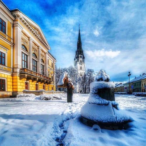 a fire hydrant covered in snow in front of a building at Clara Valis - Village House in Doľany