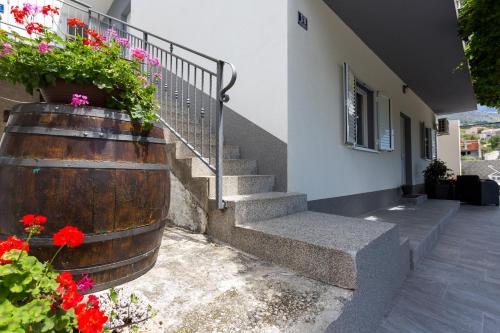 a building with stairs and flowers in a barrel at Apartments Lidija - sea view apartment with exclusive right of using hot tub or split level apartment with exclusive right of using pool in Podstrana