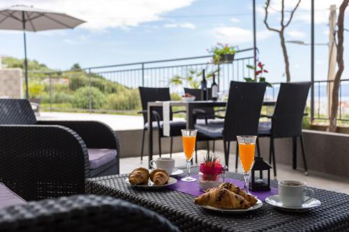 a table with food and drinks on a patio at Apartments Lidija - sea view apartment with exclusive right of using hot tub or split level apartment with exclusive right of using pool in Podstrana