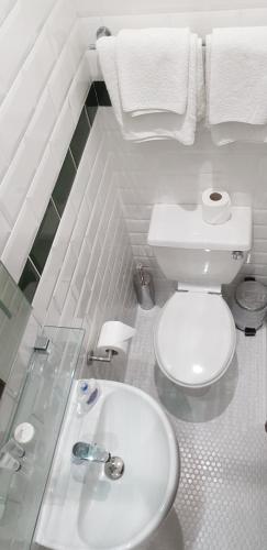 a white bathroom with a toilet and a sink at Milka's in Oxford