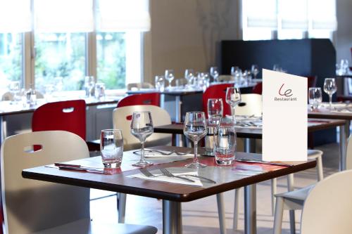 a table in a restaurant with wine glasses on it at Campanile Lille Sud - Douai Cuincy in Cuincy