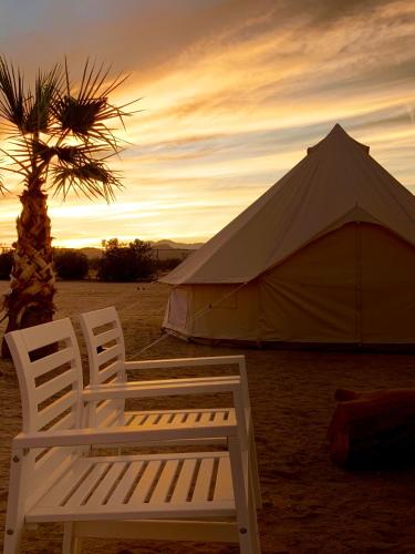 two white chairs sitting in front of a tent at The Castle House Estate in Joshua Tree