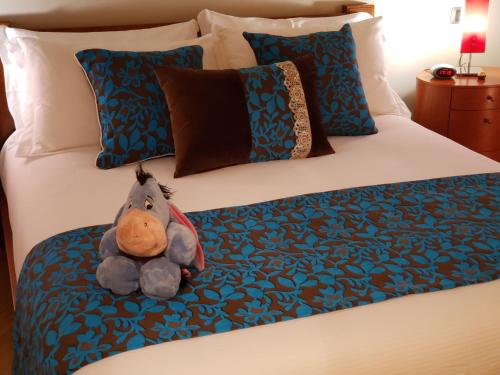 a stuffed animal is sitting on a bed at Le Chat a Pois in Aosta