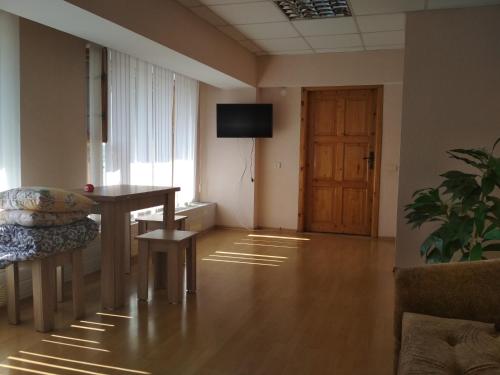 um quarto com uma mesa e uma televisão num quarto em Готель на Автовокзалі em Poltava