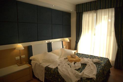 a bedroom with a bed with a table on it at Aparthotel England in Riccione