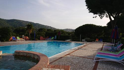 uma piscina com espreguiçadeiras em Residence Melograno em Capoliveri
