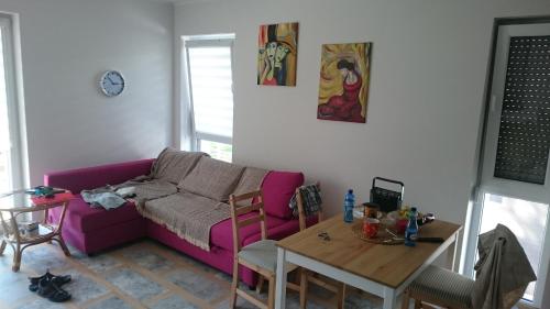 波葛佐莉扎的住宿－Baltic Pogorzelica，客厅配有紫色沙发和桌子